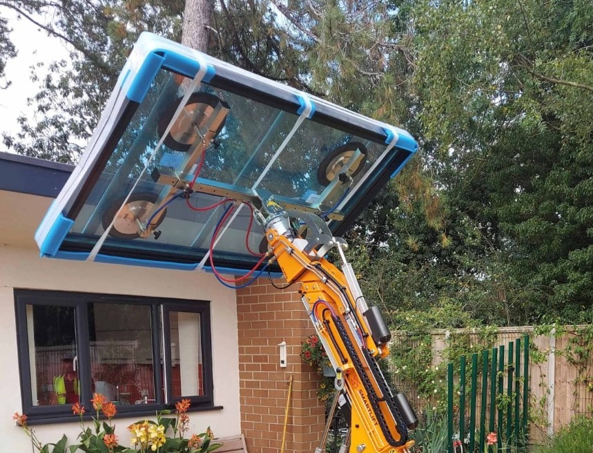 a mini crane installing a glass pane for a house's rooftop in the United States